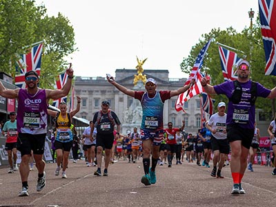 Runners complete the TCS London Marathon with Buckingham Palace in the background